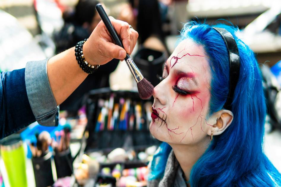 Special effects makeup artist creating a realistic zombie look with prosthetics and face paint