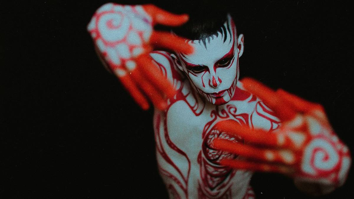 Close-up of actor wearing special effects makeup for zombies with torn skin, exposed muscle, and dried blood